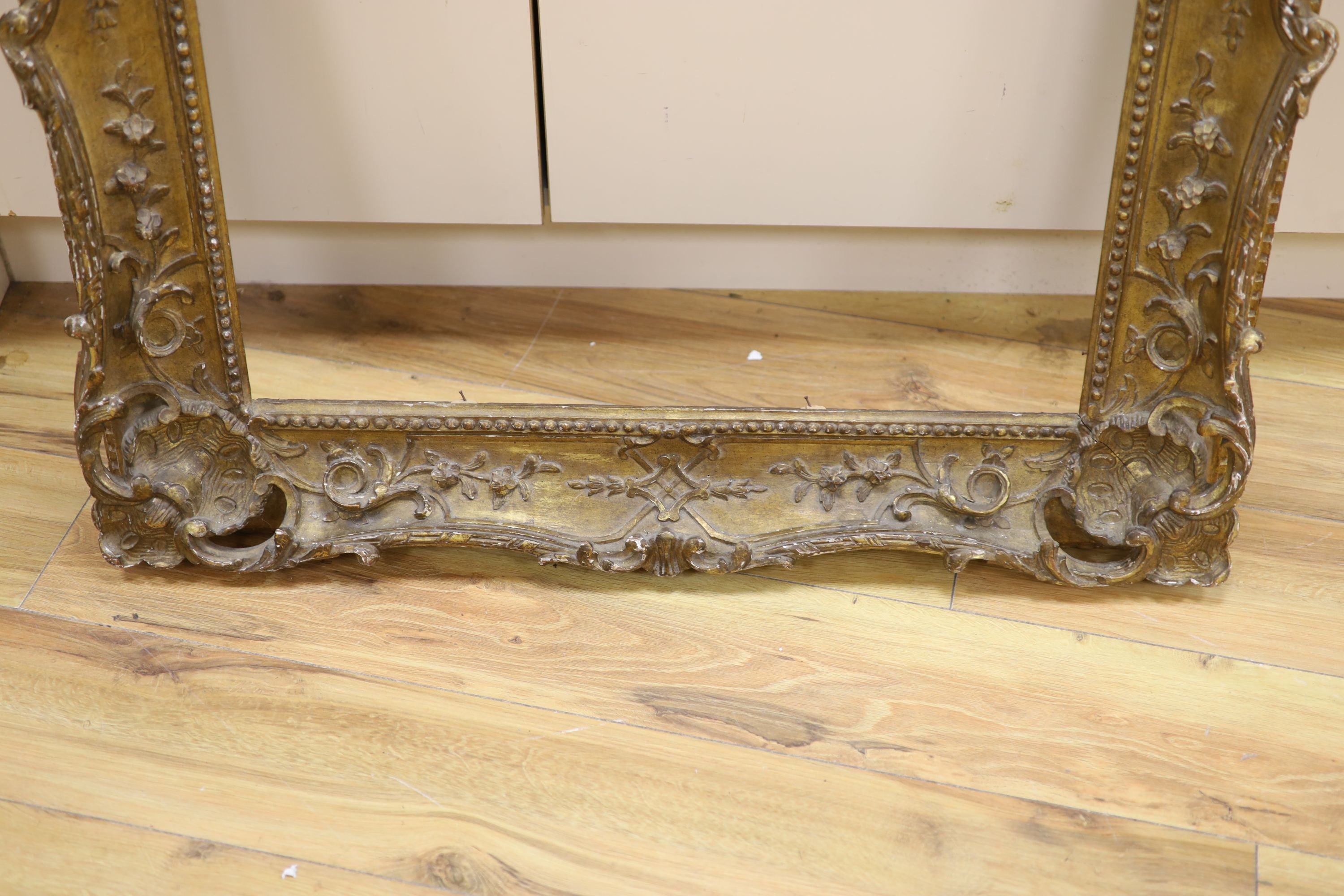 A 20th century carved giltwood scroll picture frame, aperture 78 x 63cm overall 100 x 86cm